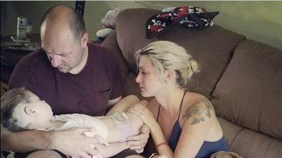 Hours before their brave daughter passed away from cancer, parents shared a devastating farewell image of them consoling her.
