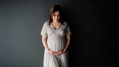 Mom poses for camera with giant belly – when photographer asks her to turn around she breaks down